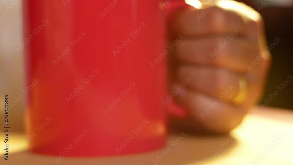 Close up Hand of young women holding a red cup and drinking hot coffee in the living room at home. Stay at home to quarantine from coronavirus pandemic. Close up Hand of young women holding a red cup and drinking hot coffee in the living room at home. Stay at home to quarantine from coronavirus pandemic.