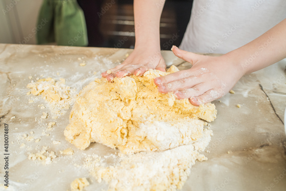 Child's hands kneading dough at home in the kitchen. Cooking at home Child's hands kneading dough at home in the kitchen. Cooking at home