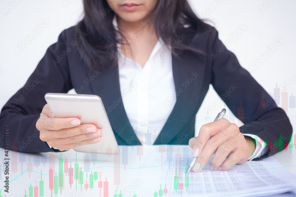 Staff business woman with black suit holding mobile and check data with charts stockmarket and grahp digital analysis. planing earn money investment and saving money future for 2022 new year. finance. Staff business woman with black suit holding mobile and check data with charts stockmarket and grahp digital analysis. planing earn money investment and saving money future for 2022 new year. finance.