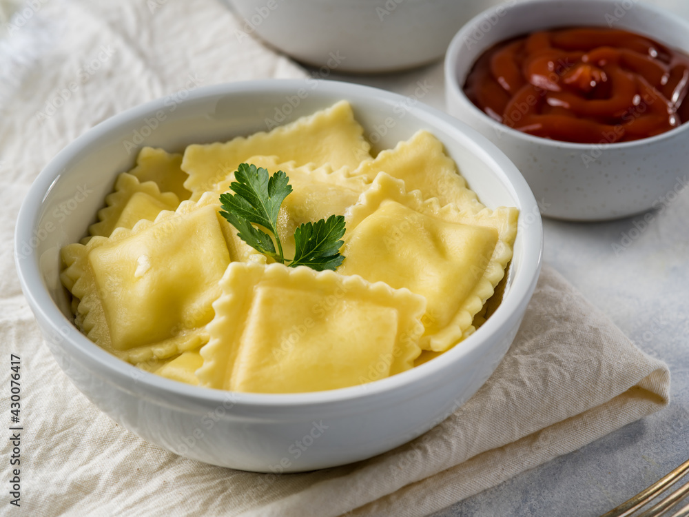 Russian dumplings or Italian ravioli with ketchup and sour cream on a light background. With cheese and mushrooms. Delicious food Russian dumplings or Italian ravioli with ketchup and sour cream on a light background. With cheese and mushrooms. Delicious food
