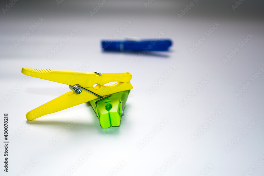 Colorful plastic clothespins on a light background. Space for your inscription. Minimalism, original and creative photography. Be different. The concept of individuality. Vertical wallpaper for a Colorful plastic clothespins on a light background. Space for your inscription. Minimalism, original and creative photography. Be different. The concept of individuality. Vertical wallpaper for a