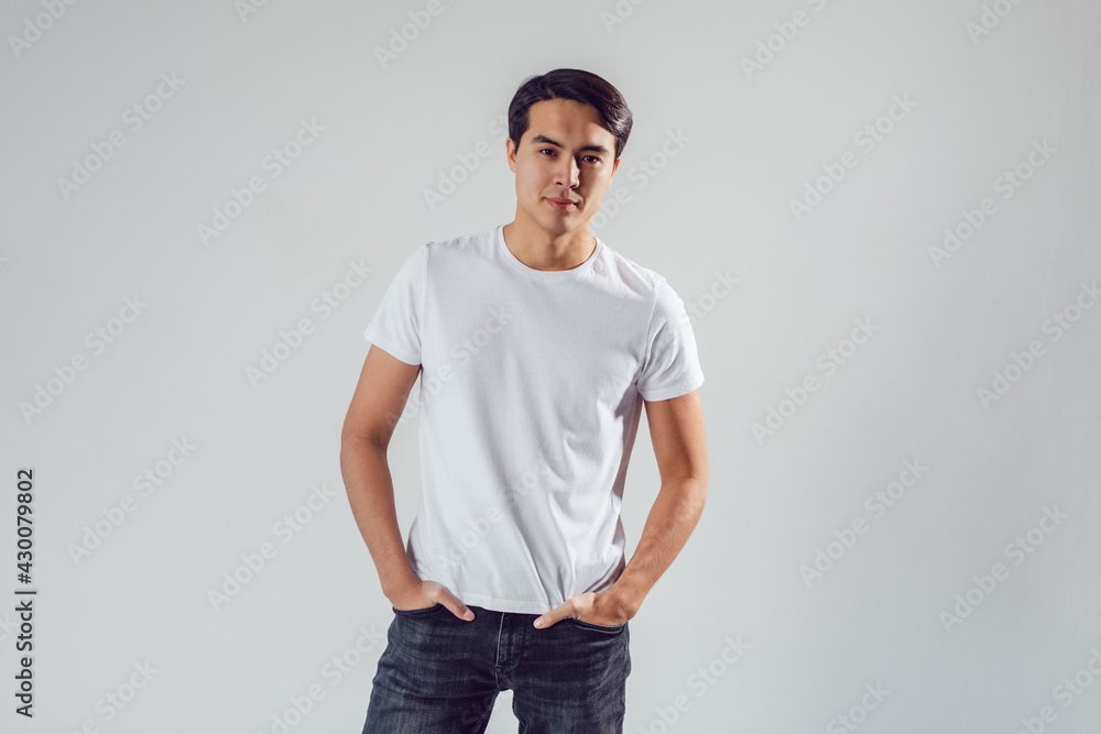 Attractive asian man in white t-shirt stands on white background. Attractive asian man in white t-shirt stands on white background.