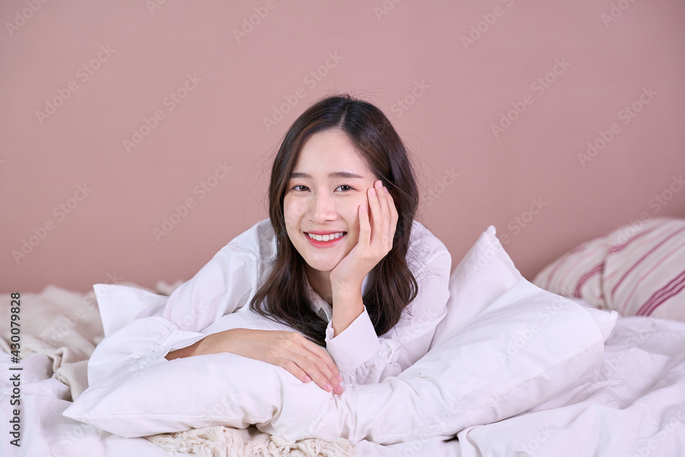Smiling cheerful beautiful pretty Asian woman clean fresh healthy white skin posing in pajamas white clothes.Girl felling relaxing and enjoy time on the bed at home Smiling cheerful beautiful pretty Asian woman clean fresh healthy white skin posing in pajamas white clothes.Girl felling relaxing and enjoy time on the bed at home