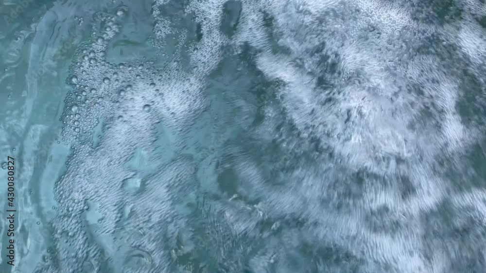 Close up fizzing, erupting clear water in empty blue swimming pool, SPA hydrotherapy concept