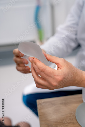 Medical silicon implants in doctor hands. Doctor holding implants in his hands.