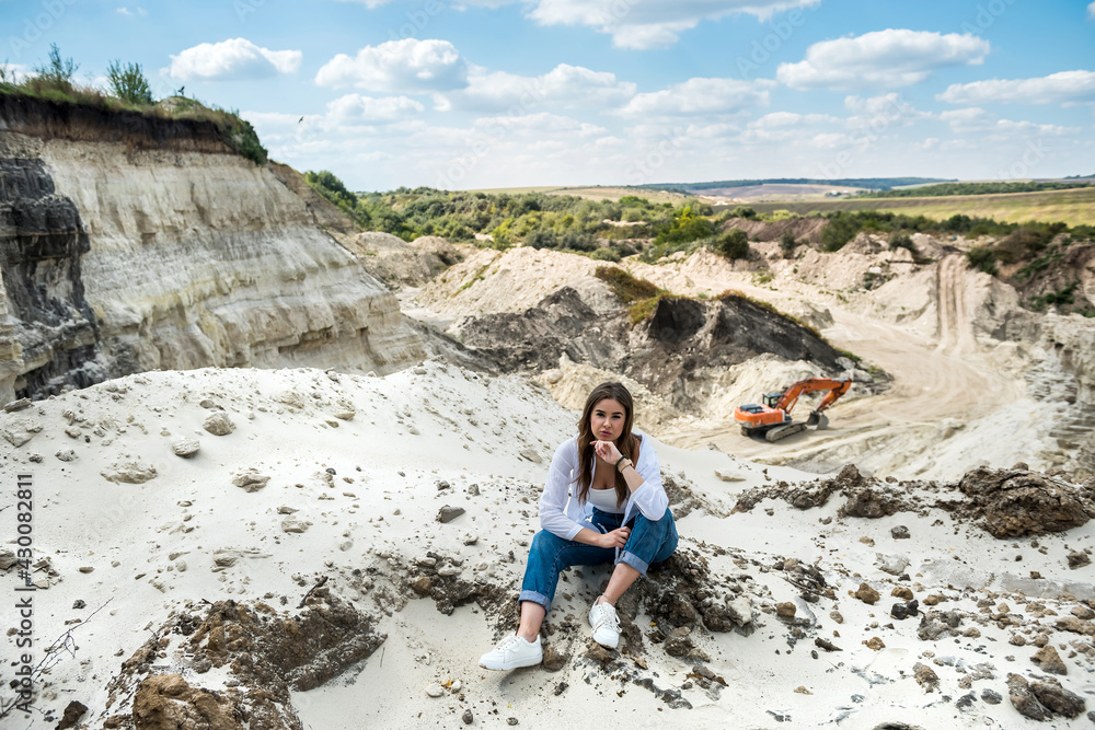 prety woman sit in sand in quarry. enjoy time in summer vacation