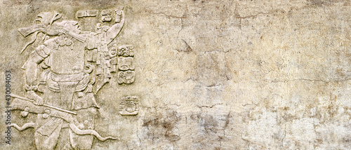 Grunge background with stone wall texture and bas-relief of a Mayan king Pakal