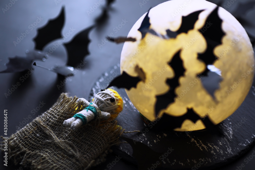 Halloween holiday concept. Old stone table in a shape of bats. Halloween paper decorations on dark background. Moon toy. Halloween holiday concept. Old stone table in a shape of bats. Halloween paper decorations on dark background. Moon toy.