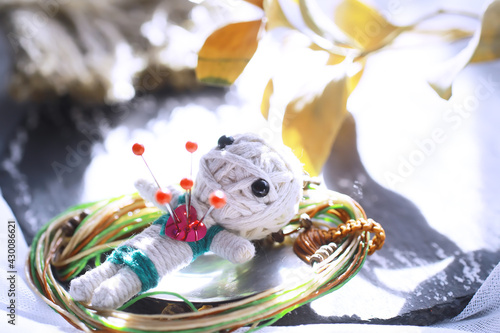 Voodoo Doll on a stone background with dramatic lighting. Mystic still life with voodoo doll and witchcraft objects. photo