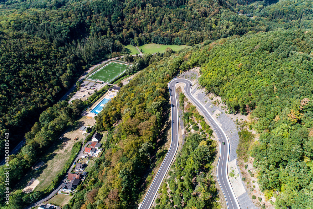 Winding road serpentine from a high mountain pass in the rhine village Bendorf Sayn Germany Aerial view