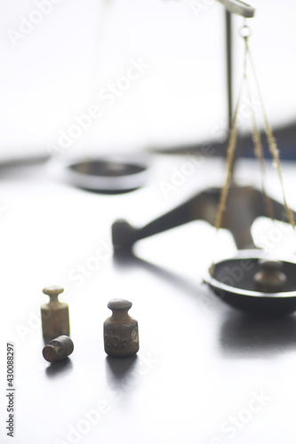 Tiny weights on vintage balance scales. Detail of Ancient old scale, Vintage old brass weight scale.