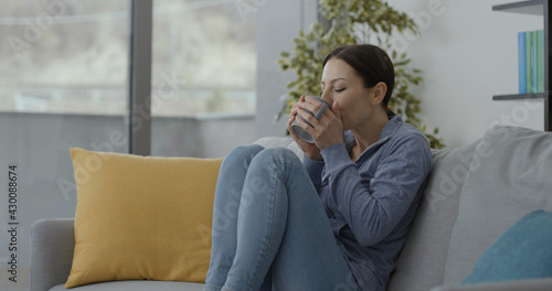 Woman sitting on the couch and drinking a tea