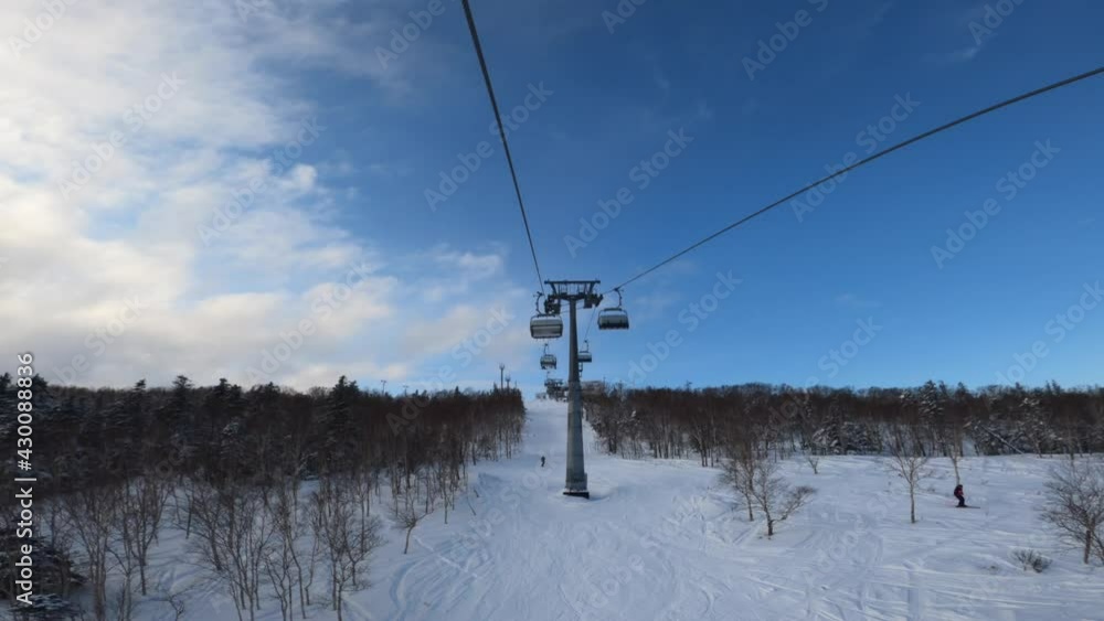 Ski lift ropeway at ski resort. Ski chairlift cable way timelapse. Chairlift in a ski resort. Scenic first person view of the beautiful ski resort while riding the chairlift up crud snow slope. Ski lift ropeway at ski resort. Ski chairlift cable way timelapse. Chairlift in a ski resort. Scenic first person view of the beautiful ski resort while riding the chairlift up crud snow slope.