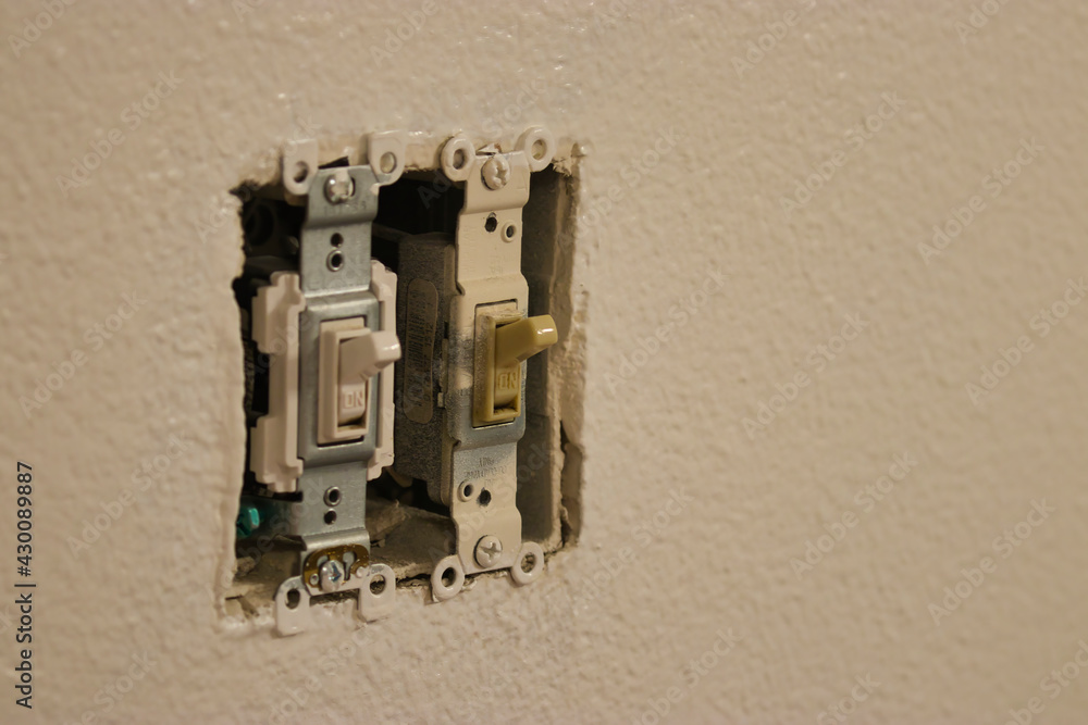 uncovered light switches in a white wall uncovered light switches in a white wall