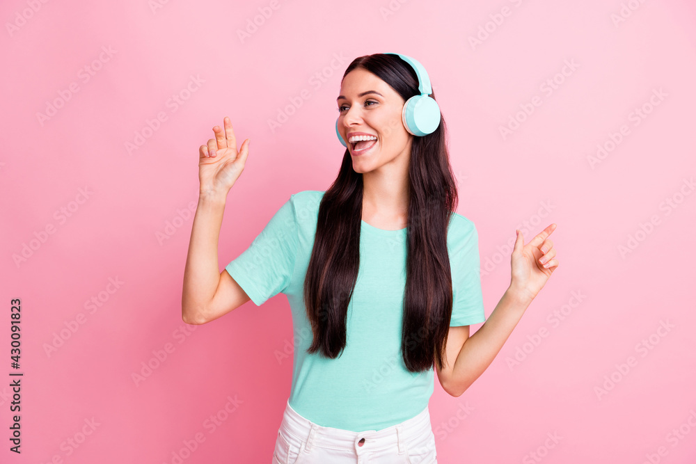 Photo of young beautiful lovely excited smiling cheerful girl in headphones dancing isolated on pink color background Photo of young beautiful lovely excited smiling cheerful girl in headphones dancing isolated on pink color background