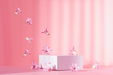 Bright spring mock up for cosmetic and product display with three white square podiums, stream of tender flowers flying in sun beam on pastel pink background.