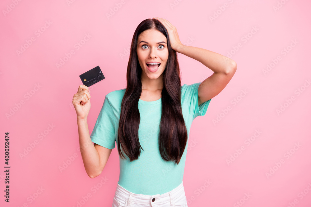 Photo of young happy beautiful crazy amazed girl hold hand on head show credit card isolated on pink color background Photo of young happy beautiful crazy amazed girl hold hand on head show credit card isolated on pink color background