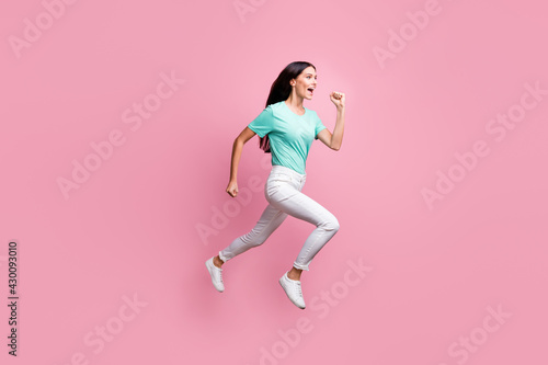 Full size profile side photo of young attractive crazy positive girl running in air isolated on pink color background