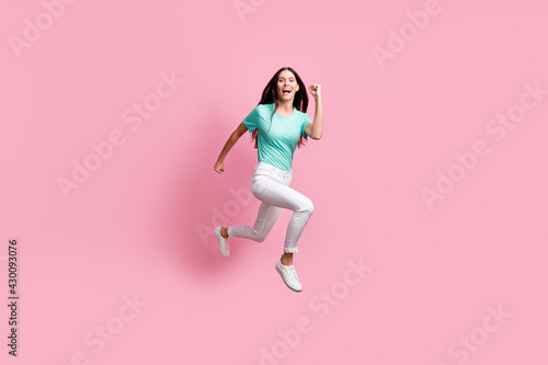 Full size profile side photo of young beautiful lovely happy crazy smiling girl running in air isolated on pink color background