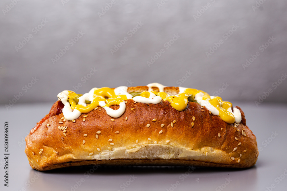 hotdog with sausage and sauce on a gray background hotdog with sausage and sauce on a gray background