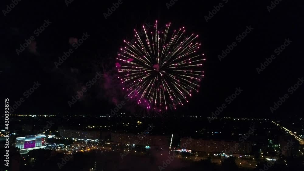 Bright festive fireworks on a dark sky background late at night. Beautiful flashes of fireworks in sky aerial view. Multicolored flashes. Glitter. City Day holiday on New Year's Eve. Bright festive fireworks on a dark sky background late at night. Beautiful flashes of fireworks in sky aerial view. Multicolored flashes. Glitter. City Day holiday on New Year's Eve.