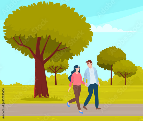 Couple walking in park. Young guy and girl holding hands walking in summer garden, romantic walk. Lovers man and woman met on date outdoor. Romantic promenade on city green alley, active lifestyle