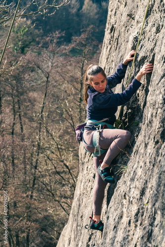 Female climber looks at where she places her feet on the rock.