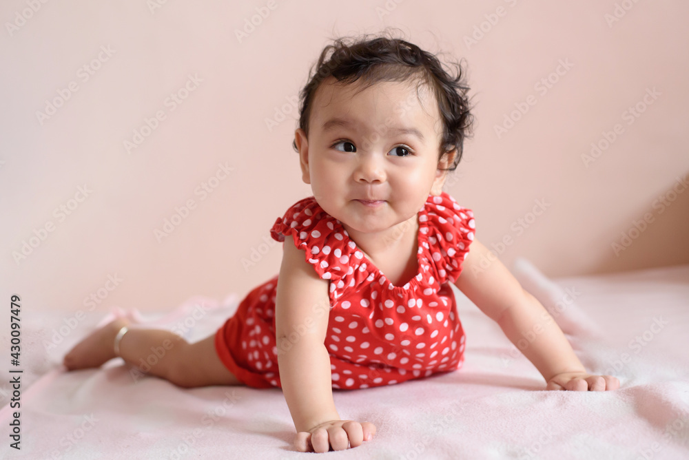 Portrait of a cute happy little Asian baby girl wearing red dress looking out, baby expression concept Portrait of a cute happy little Asian baby girl wearing red dress looking out, baby expression concept