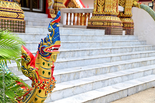 Closeup of Colorful Naga statue in front of the temple door at Bangkok, Thailand.