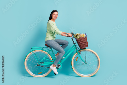 Fototapeta Naklejka Na Ścianę i Meble -  Profile side view of attractive cheerful sporty girl riding bike spending holiday day isolated over bright blue color background