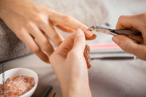 Manicurist using cuticle pusher photo