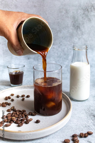 person pouring milk in coffee decoction - morning coffee