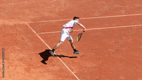 Tennis player athlete in action on clay tennis court during the game. Courage of professional athlete in competition. Individual sport © Elena