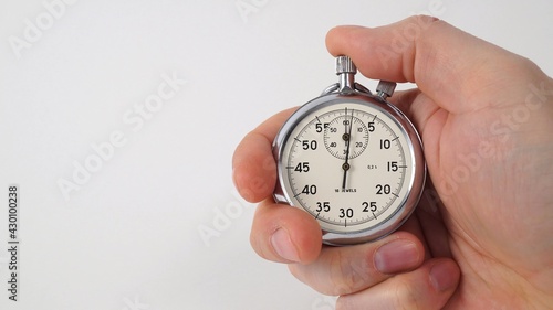 Human hand pressing stopwatch button on white.