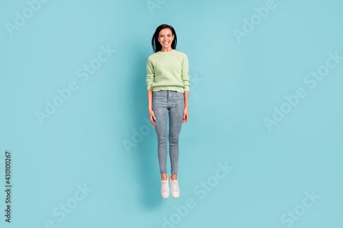 Full length body size view of pretty slender glad cheerful girl jumping having fun good nice look isolated over bright blue color background