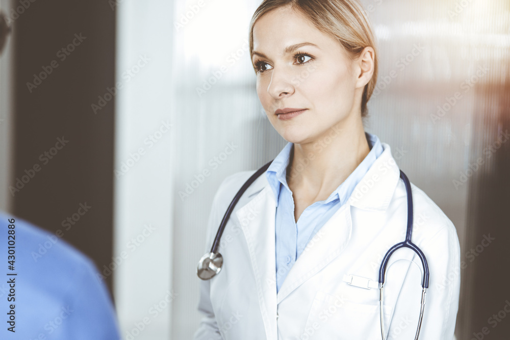 Friendly female doctor and patient man discussing current health examination while sitting in clinic. Perfect medical service in hospital. Medicine and healthcare concept Friendly female doctor and patient man discussing current health examination while sitting in clinic. Perfect medical service in hospital. Medicine and healthcare concept