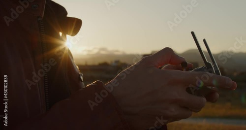 Mani pilotano drone in spiaggia con il radiocomando photo