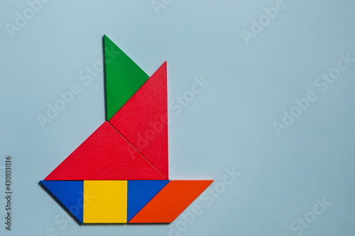 Ship of colorful tangrams in blu background 