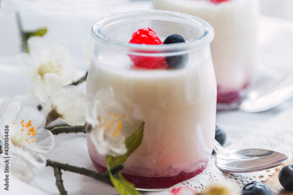 Greek yogurt with raspberries and blueberries in glass jars Greek yogurt with raspberries and blueberries in glass jars