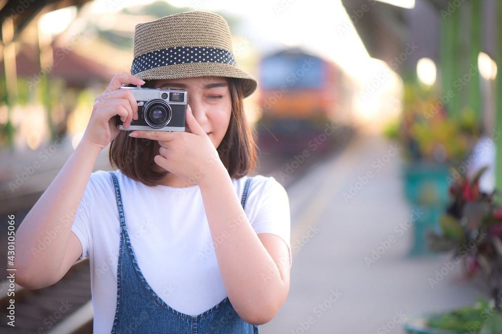 Young asian woman tourist standing with photo camera at train station