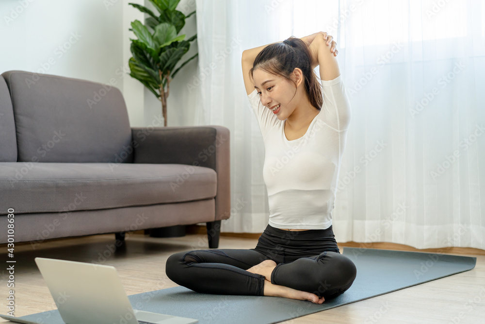 Fit, sporty asian young beautiful woman, girl sitting physical or pilates, watching trainer online on laptop computer, training in living room.Workout fitness exercise people in sportswear at home. Fit, sporty asian young beautiful woman, girl sitting physical or pilates, watching trainer online on laptop computer, training in living room.Workout fitness exercise people in sportswear at home.