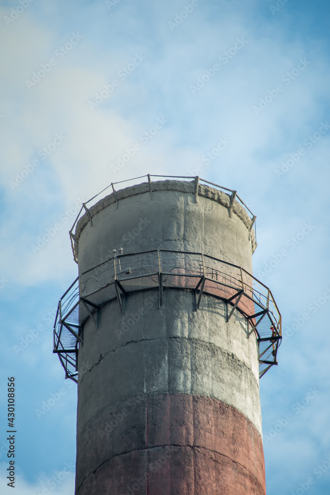 Smoke from factory pipes against blue sky. Concept of oil and gas processing plants, coal mining and minerals Smoke from factory pipes against blue sky. Concept of oil and gas processing plants, coal mining and minerals