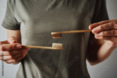 Woman hold bamboo toothbrushes, close up
