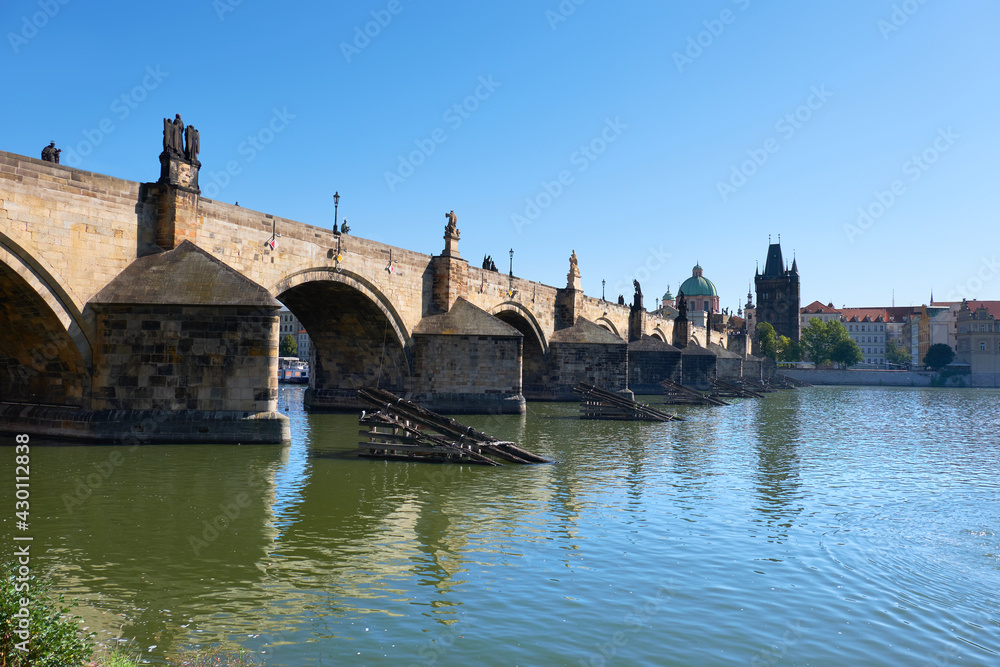 Charles Bridge in Prague with reflection in water. Romantic travel views of Prague, Czech Republic, in Summer with Charles Bridge, blue sky and calm water. Charles Bridge in Prague with reflection in water. Romantic travel views of Prague, Czech Republic, in Summer with Charles Bridge, blue sky and calm water.
