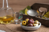 Black and green olives in a small bowl. Variation of olives in a small bowl on a rustic background