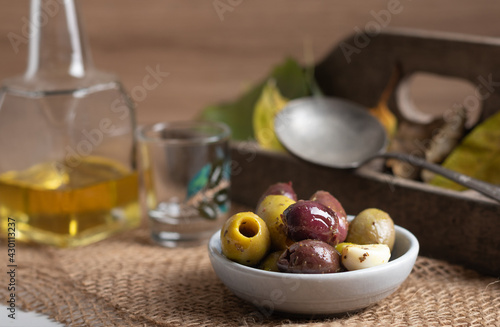 Black and green olives in a small bowl. Variation of olives in a small bowl on a rustic background