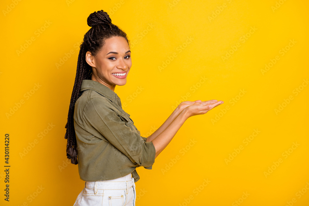 Photo portrait profile of woman holding blank space in two hands isolated on vivid yellow colored background Photo portrait profile of woman holding blank space in two hands isolated on vivid yellow colored background