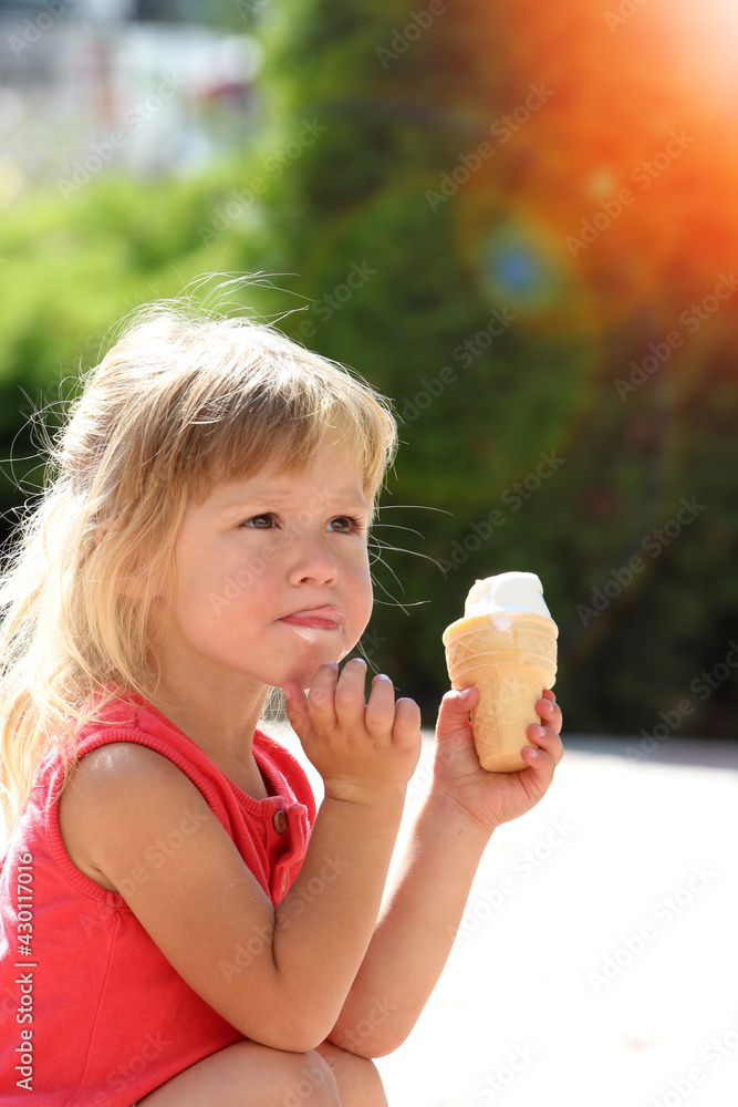 Happy child eating ice cream on the nature of the park