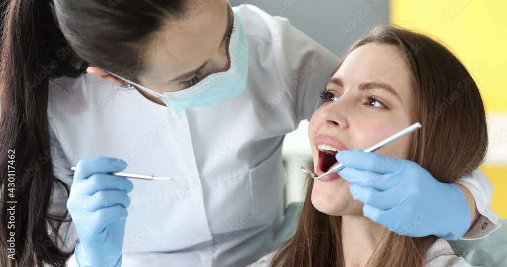 Dentist with protective mask examining teeth of female patient 4k movie Dentist with protective mask examining teeth of female patient 4k movie