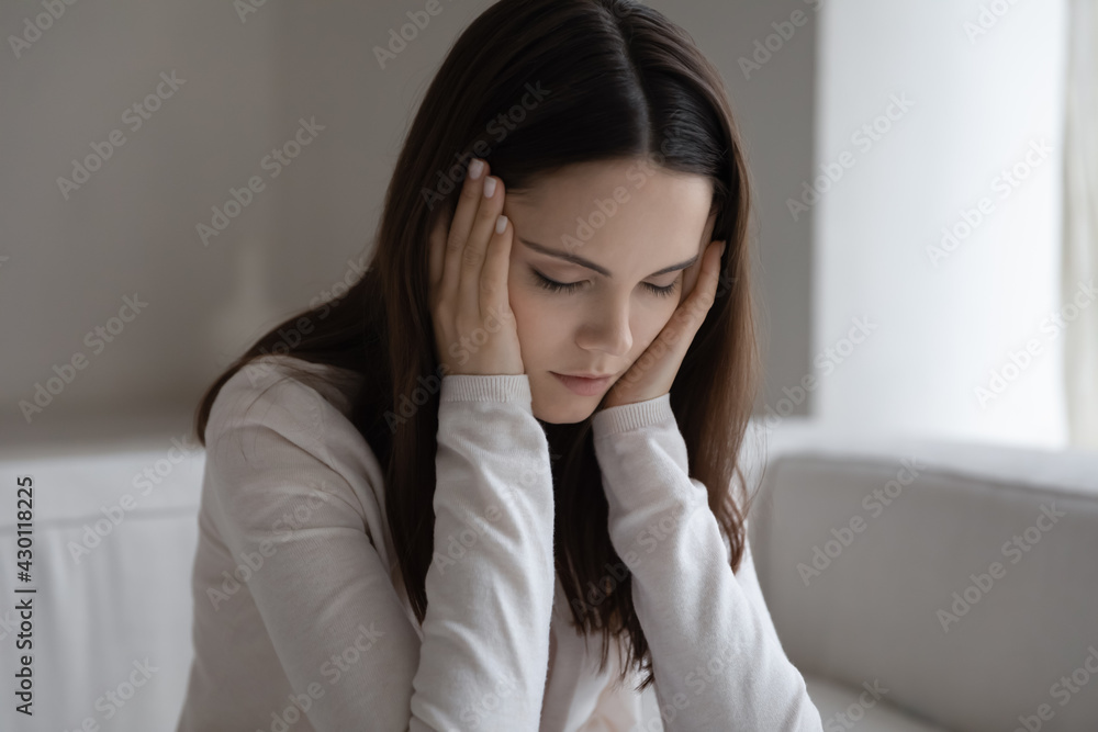 Tired millennial teen girl feeling strong headache, migraine pain, holding head. Unhappy young woman suffering from depression, anxiety, panic attack, nervous system and mental health problem Tired millennial teen girl feeling strong headache, migraine pain, holding head. Unhappy young woman suffering from depression, anxiety, panic attack, nervous system and mental health problem